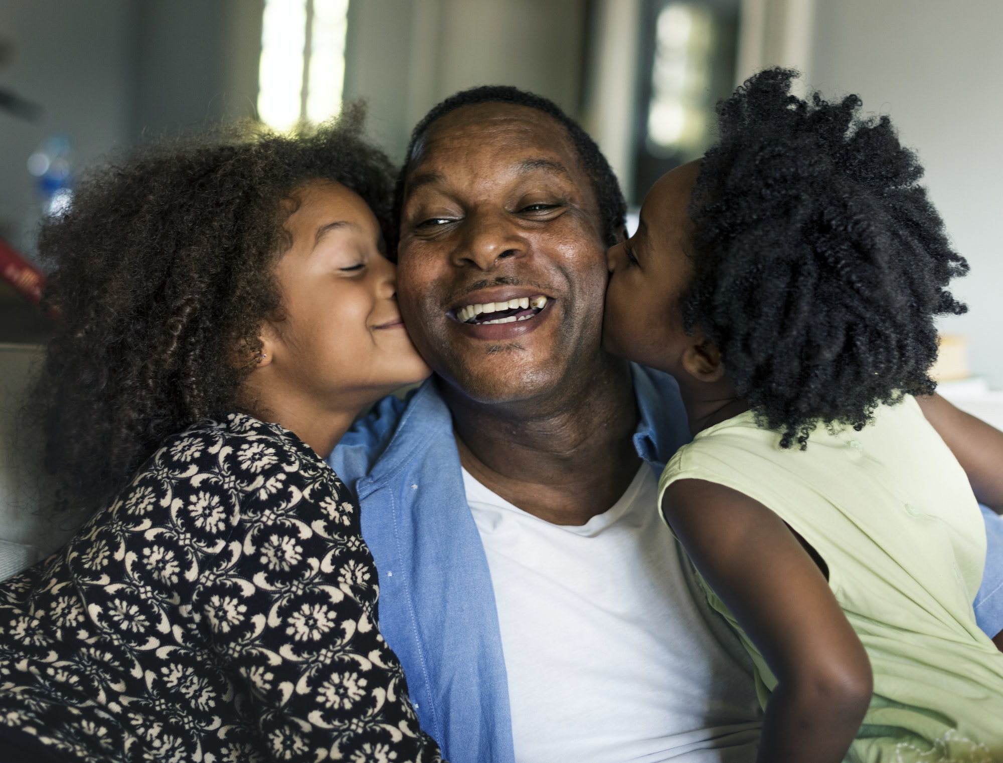 African children kissing their father